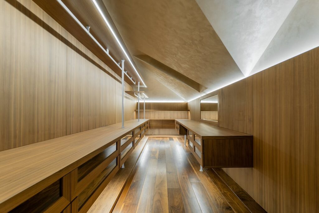 pexels-photo-20705883 Spacious contemporary walk-in closet with sleek wooden design and ambient lighting.