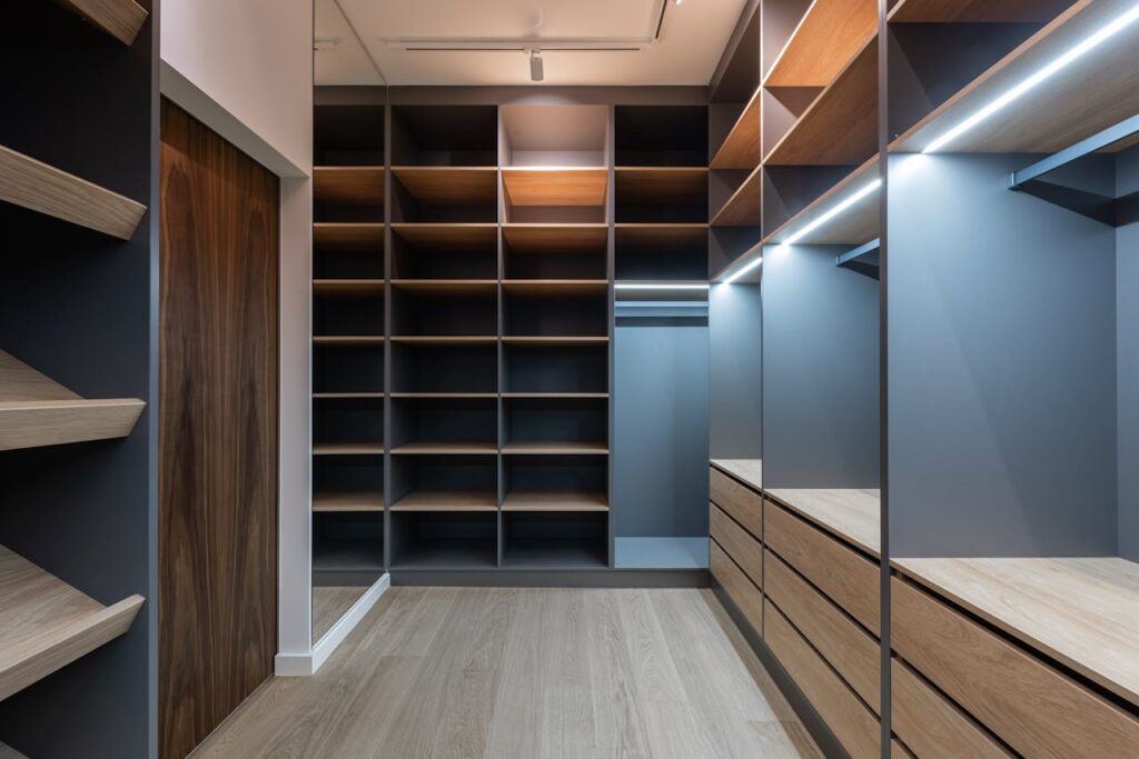 pexels-photo-6585750 Interior of modern spacious wardrobe room with empty shelves near door and mirror